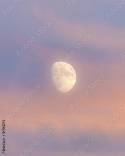 Ethereal atmospheric moon glowing in a colourful sunset sky surrounded by pink hazy clouds. Toronto Ontario