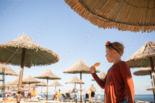 happy boy with ice cream relaxing on the beach  photo