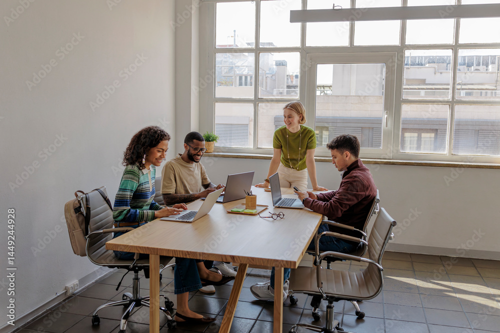 Diverse business team collaborating on project in modern office Diverse business team collaborating on project in modern office