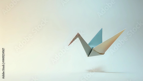 A delicate origami crane gracefully suspended mid-air, showcasing intricate folds against a soft gradient background