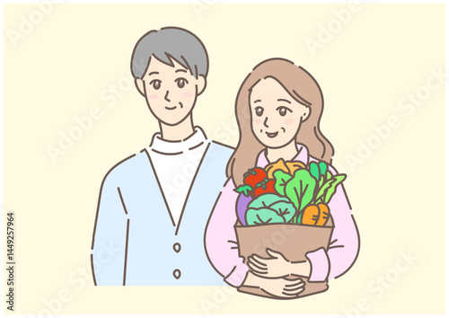 たくさんの新鮮な野菜を抱えて歩く、買い物帰りの素敵な初老の夫婦