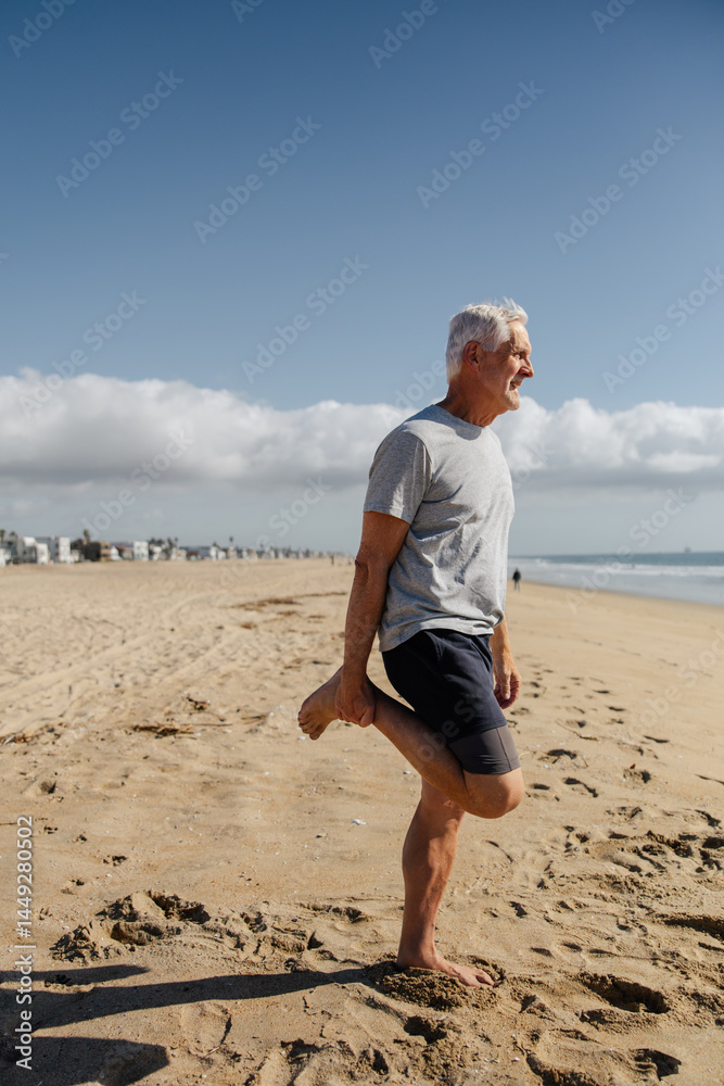 Active Senior Stretching on Beach Under Clear Sky Active Senior Stretching on Beach Under Clear Sky
