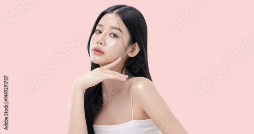 Glowing skin make up style of beautiful young Asian model isolated on pink background.