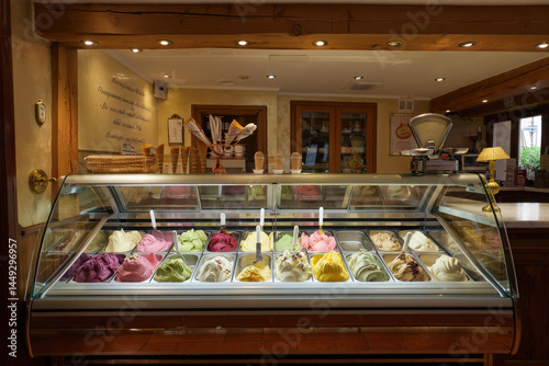  Interior of a traditional Italian gelateria with a refrigerated display case showcasing assorted gelato flavors
