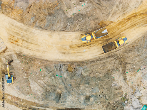 Aerial View of Construction Trucks on Dirt Road photo