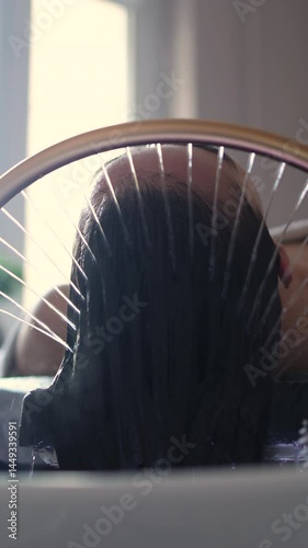 Close-up of a woman receiving a head massage during a Japanese head spa treatment with water flowing from a special hair washing tool, focusing on the scalp relaxation and beauty therapy