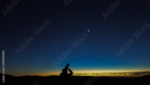 Obraz na płótnie Amateur astronomer looking at the evening skies, observing planets, stars, Moon and other celestial objects with binoculars. w salonie