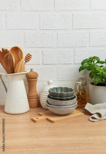 Obraz na płótnie Kitchen utensils, bowls and spices resting on wooden countertop with white brick wall background w salonie