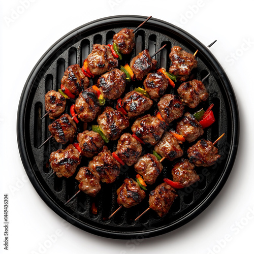 An overhead view of a circular black grill with a single piece of shish kebab