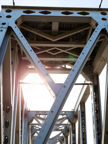 A close examination of the loadbearing trusses on a modular bridge component highlighting their intricate weblike design. The interplay of light reinforces the engineering maxim of