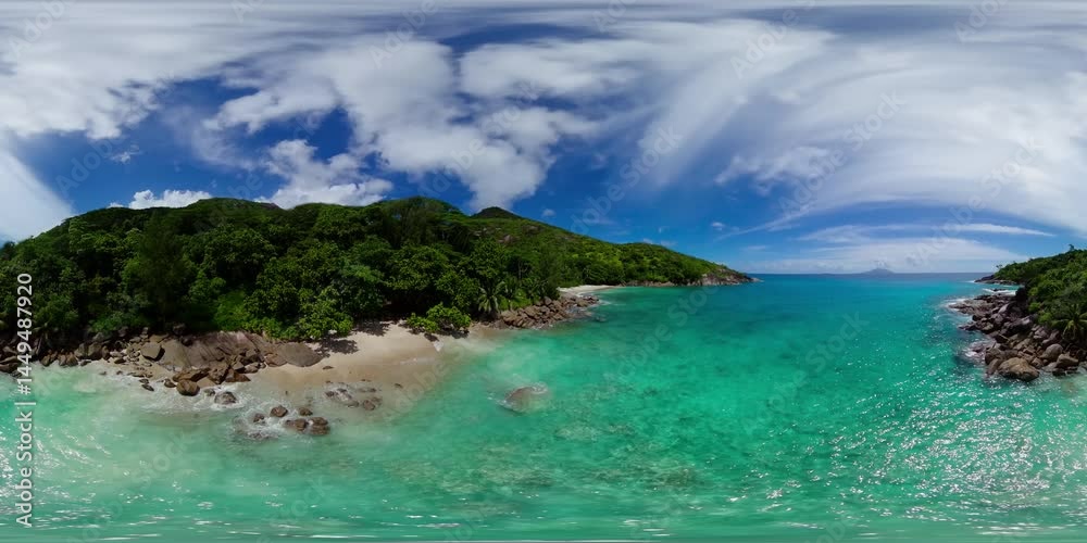 Aerial drone of crystal clear waters caress a remote beach, bordered by lush green forest and rocky outcrops. Anse Major, Seychelles. 360 Degree view. Aerial drone of crystal clear waters caress a remote beach, bordered by lush green forest and rocky outcrops. Anse Major, Seychelles. 360 Degree view.