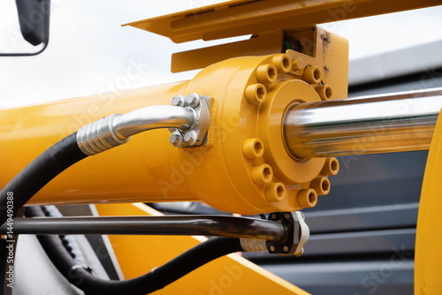 Hydraulic piston against the sky. a fragment of a yellow bulldozer