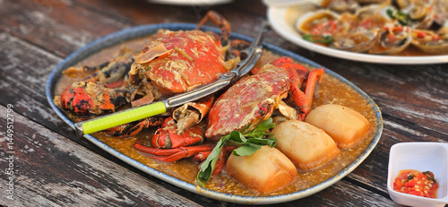 Chilli crab Singapore style serving with fried bun on the timber table