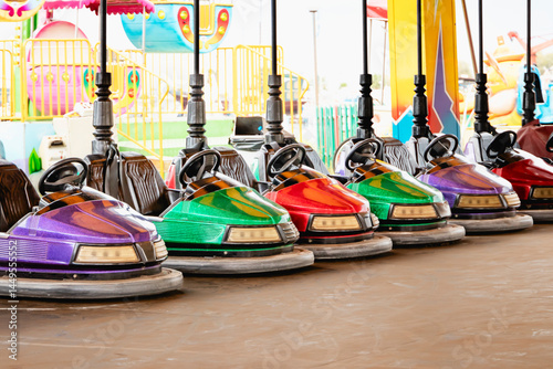 Obraz na płótnie Colorful bumper cars are lined up at a vibrant amusement park, inviting thrilling excitement and joy at the amusement park w salonie