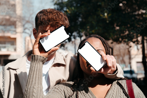 Anonymous man and woman with blank mobile phones on their faces