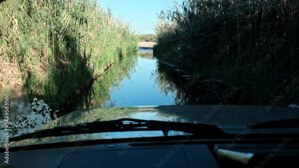 custom made wallpaper toronto digitalSUV vehicle driving through a flooded river crossing with reeds on either side.
