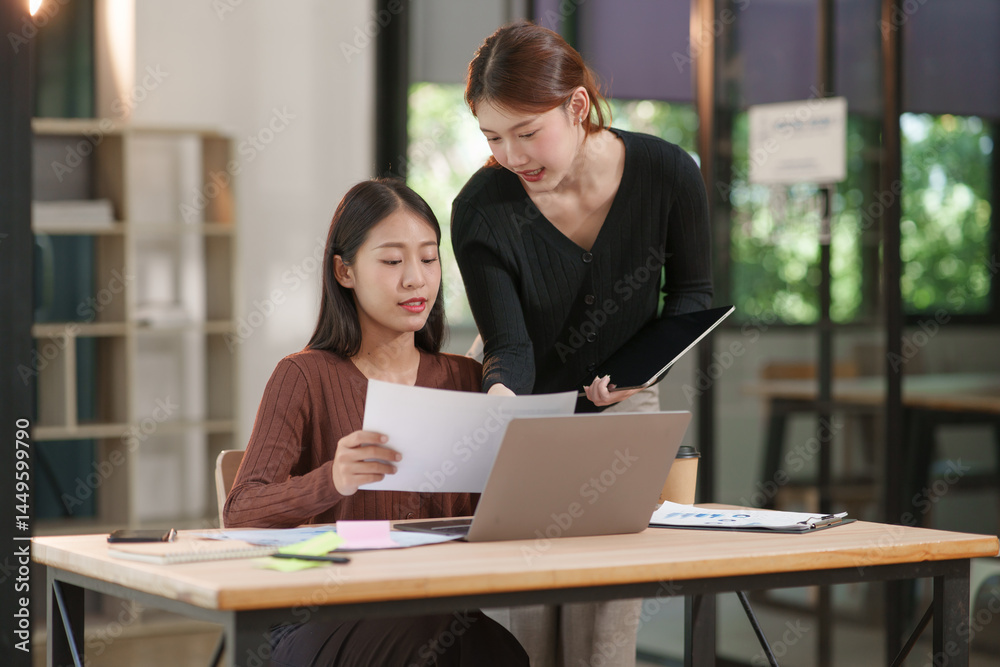 Group of Asian businesswomen working on documents in an office. Group of Asian businesswomen working on documents in an office.