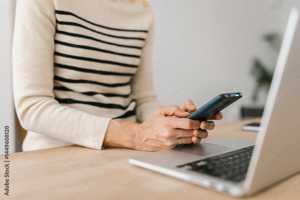 Naklejka premium Close-up view of woman hands using mobile phone device at office workplace. Technology lifestyle and business concept.