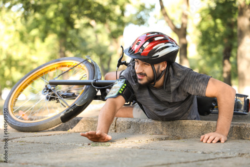 Young man fallen off his bike in park