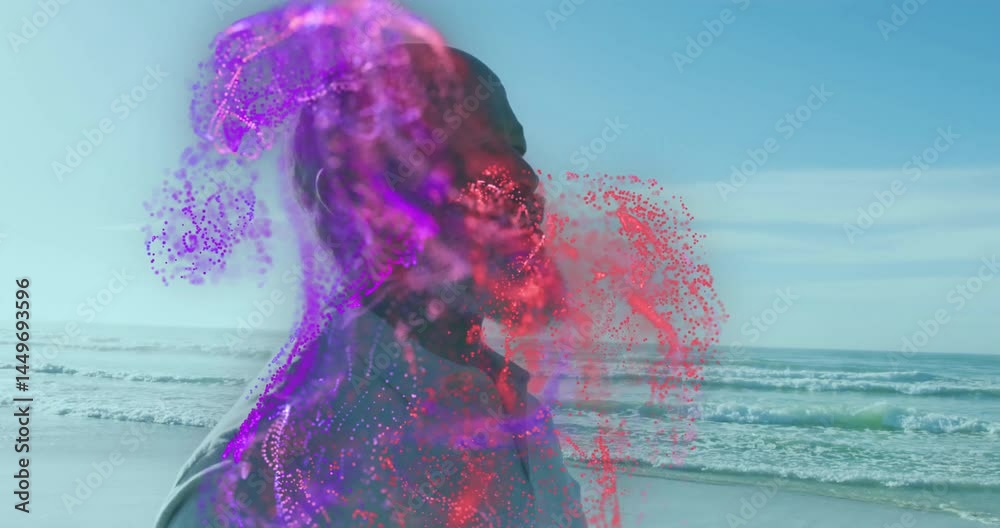 man standing on beach, technology concept unfolding with swirling purple and red particle effects