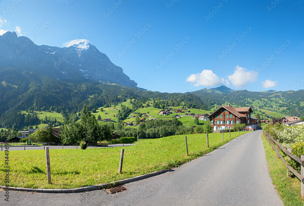 chalet beside road in Grindelwald tourist resort, view to Eiger mountain and Kleine Scheidegg