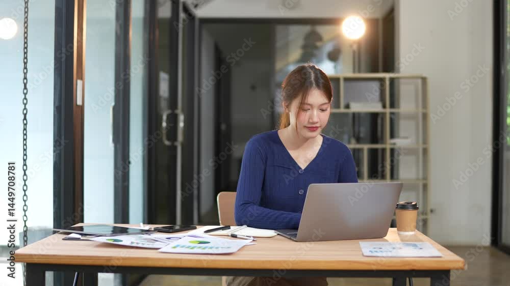 Asian businesswoman working at desk using laptop and notebook talking to client or office building, slow motion footage Asian businesswoman working at desk using laptop and notebook talking to client or office building, slow motion footage