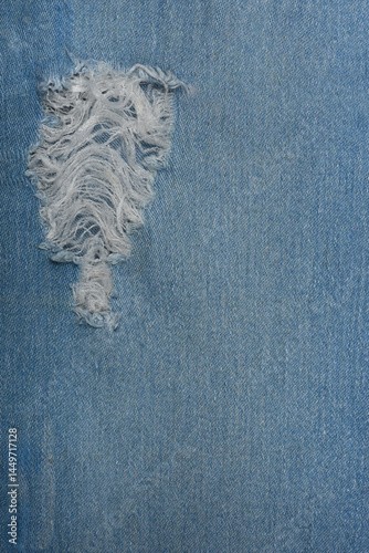 Ripped blue hipster jeans material. Destroyed denim Cloth texture. Close up.