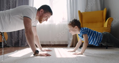 A man and boy do pushups together, showcasing fitness and bonding