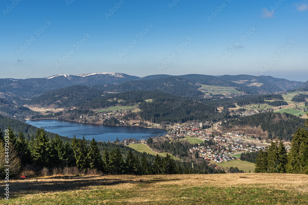 Fototapeta premium View of the Titisee lake and the spa town of the same name from Hochfirst, with the Feldberg lightly covered in snow in the background, Baden-Wuerttemberg, Germany
