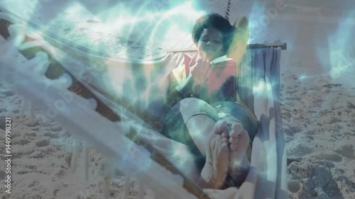 Woman reclining on hammock reading book on beach, with animated educational icons floating