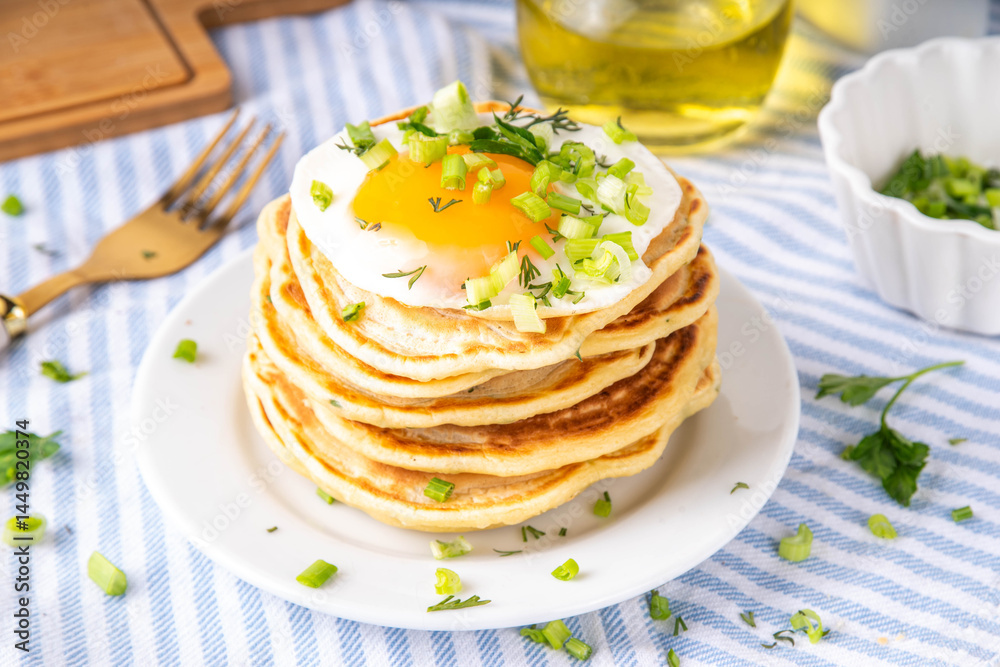 Tasty savory breakfast pancakes with spring green onion and fried eggs Tasty savory breakfast pancakes with spring green onion and fried eggs