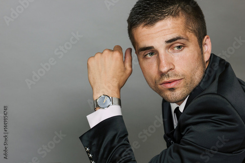 Quadro su tela Close-up portrait of young man in elegant suit and white shirt on gray background