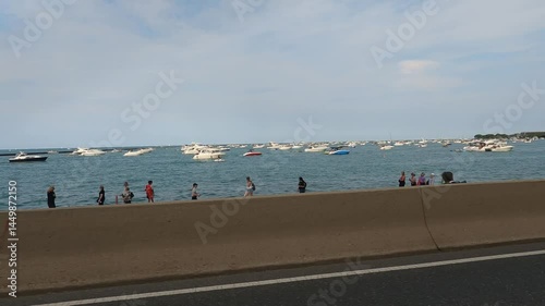 Desde el interior de un coche en circulacion por la costa del lago Michigan en Chicago-USA, embarcaciones de recreo están amarradas, hay muchos bañistas en la playa