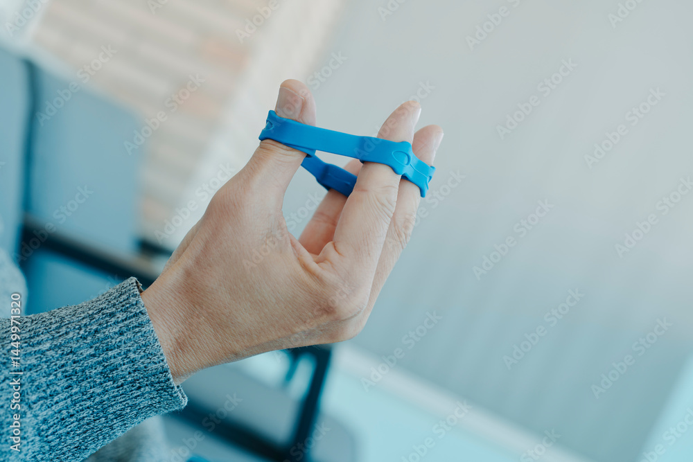 man exercising his fingers with an elastic band