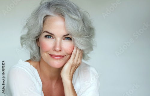 Adult elderly and beautiful woman 50 years old. Smiling charming mature woman , touches her cheek. Beauty and care cosmetology for mature facial skin. Makeup and cosmetology. adult skin, older lady