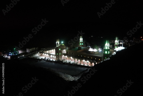 The ariel view at night of Aboul Hassan el Shazly Mosque in Homaithera in southern Egypt with its green lights shining the in middle of the hills and mountains