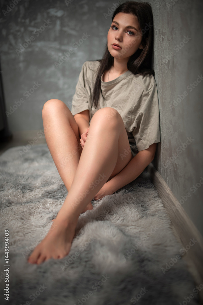 Naklejka premium Portrait of a young beautiful dark-haired girl in a home studio.
