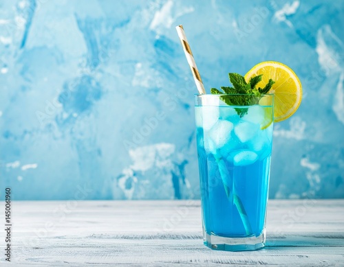A refreshing blue cocktail garnished with lemon and mint, served on a wooden table against a textured blue background, evoking a cool, summery vibe.