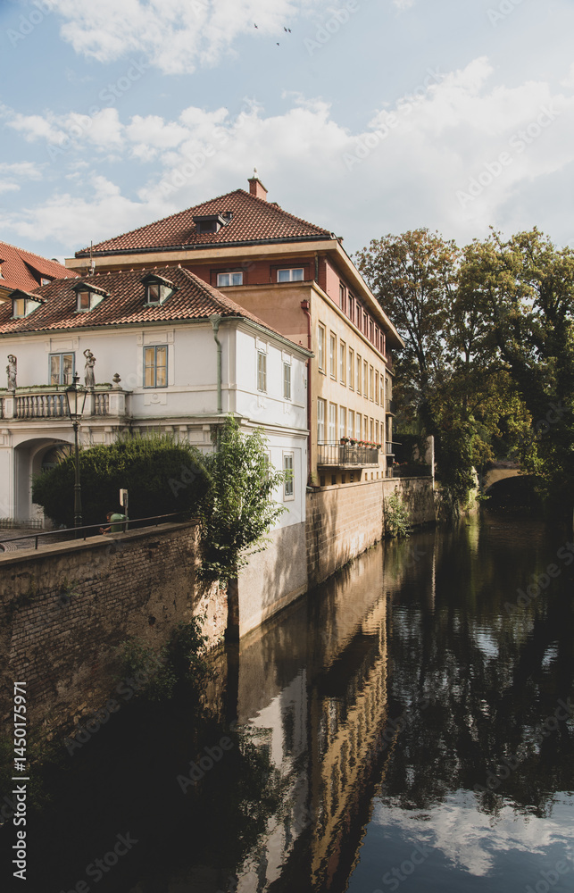 Fototapeta premium Canal between historic buildings with reflections and blue sky