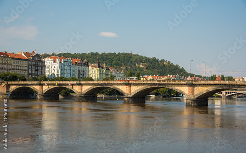 Historic bridge in Prague with red trams