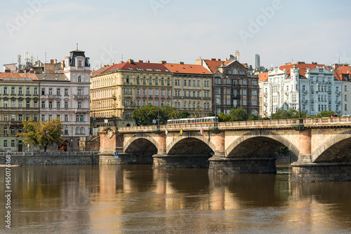 Historic bridge in Prague with red trams