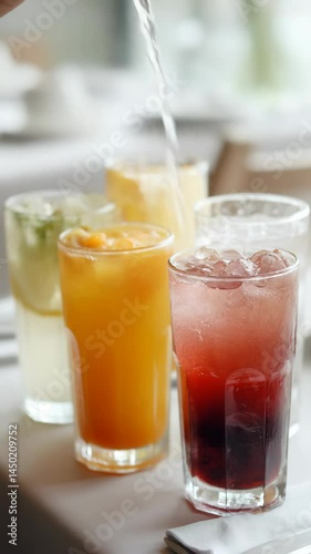 Wallpaper Mural Refreshing beverages in glasses on a table, water pouring into a glass with ice, colorful drinks assortment, refreshment concept Torontodigital.ca