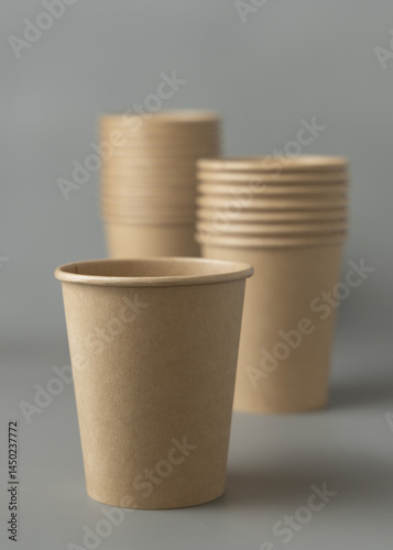 Obraz na płótnie Disposable beige kraft paper cups on a gray closeup, mockup. No plastic and sustainable lifestyle w salonie