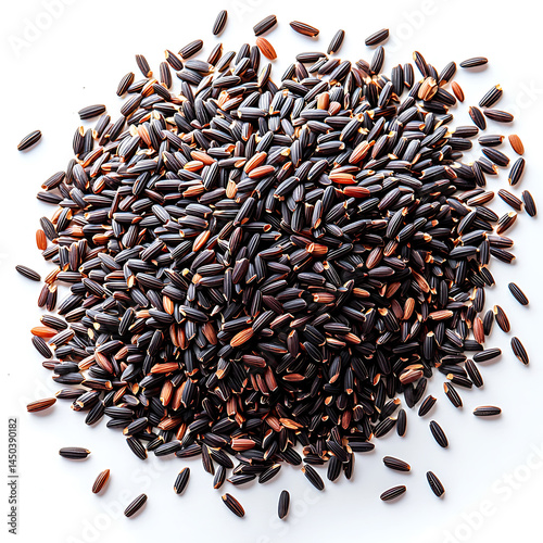 Obraz na płótnie A pile of uncooked black rice grains displaying a rich dark color with hints of reddish-brown scattered on a white surface. w salonie