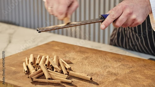 Food preparation. Close-up of a chef's hands grating cinnamon sticks while making cinnamon powder. Slow motion 50fps.