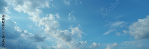 Celestial Canvas: A vibrant expanse of azure blue sky adorned with soft, fluffy clouds, capturing the essence of a perfect day.