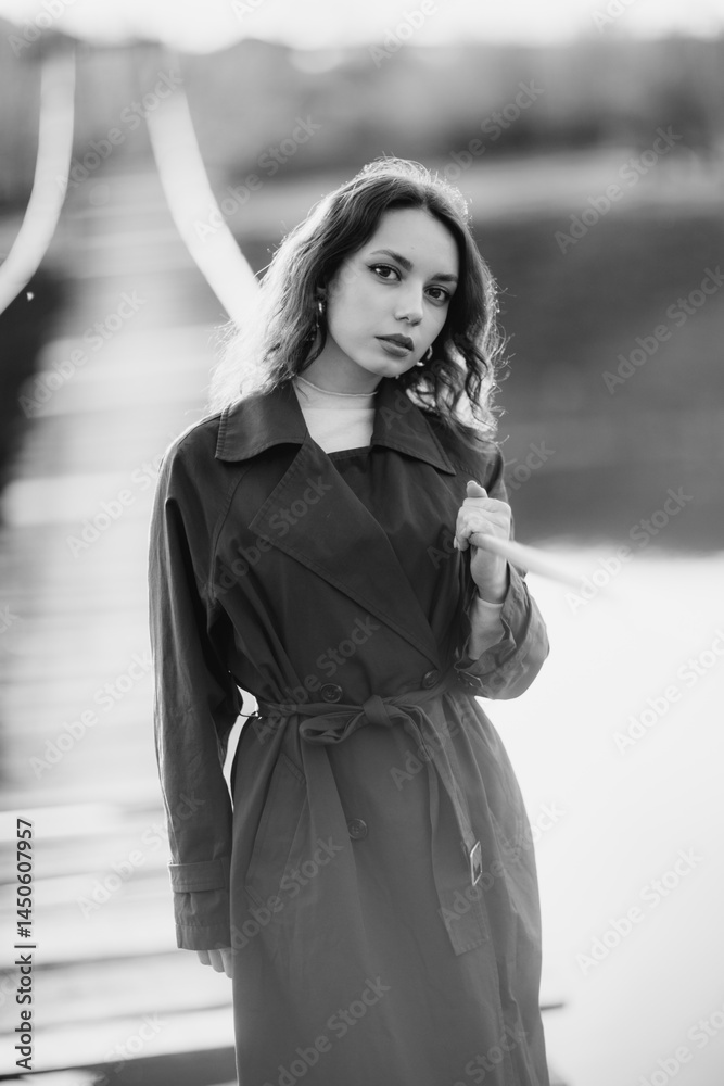 beautiful brunette european girl in blue trench coat at nature. Young lady with beautiful face and lips.