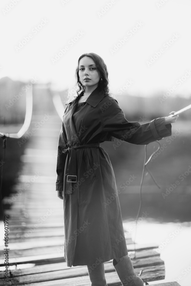 beautiful brunette european girl in blue trench coat at nature. Young lady with beautiful face and lips.
