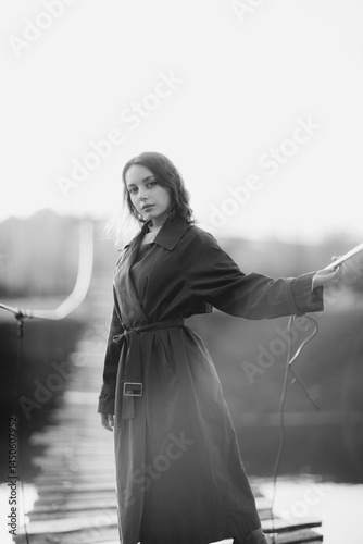 beautiful brunette european girl in blue trench coat at nature. Young lady with beautiful face and lips.
