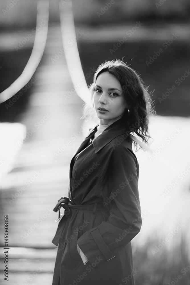 beautiful brunette european girl in blue trench coat at nature. Young lady with beautiful face and lips.